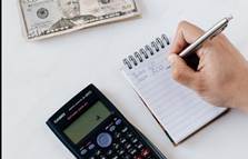 Crop unrecognizable financial worker calculating profit using notebook and calculator